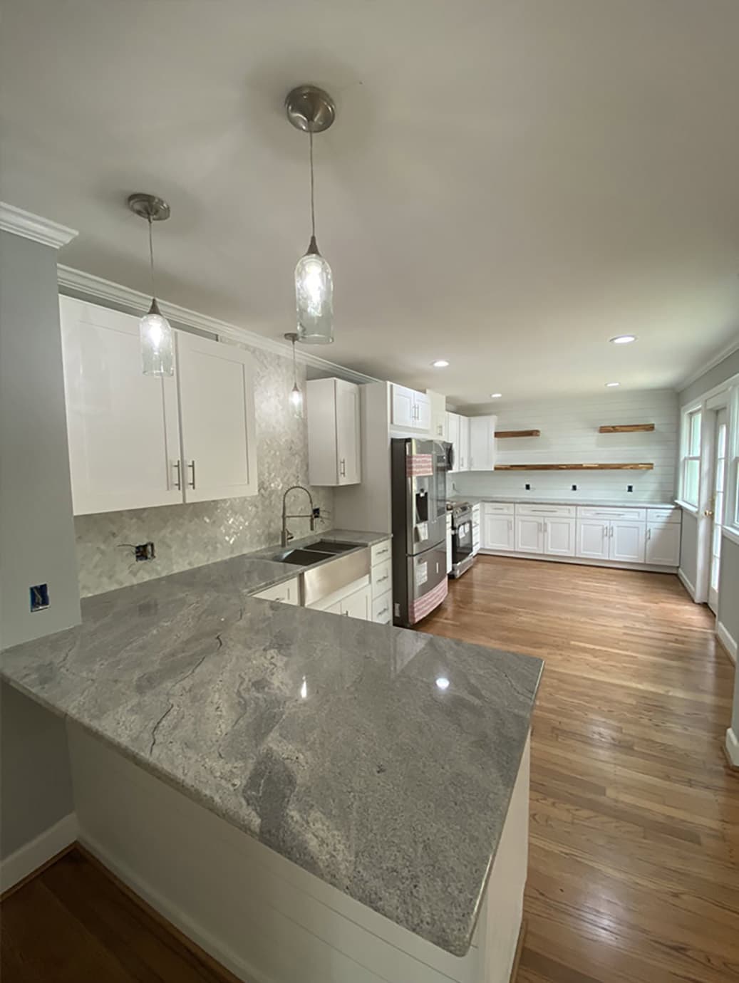 Completed Allison Builders galley kitchen with stone counters and oak flooring